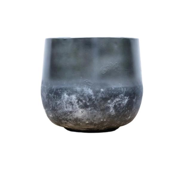 Tarnished metal bowl with a rounded base and white patina around the lower half, frost-like texture visible at the bottom.