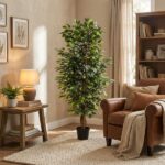 Tall potted indoor tree in a cozy living room beside a brown leather sofa, with a side table, lamp, and a bookshelf in warm light.