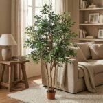 Tall leafy houseplant in a terracotta pot stands in a cozy living room beside a beige sofa and wooden side table.