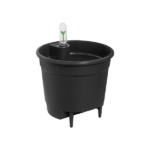 Black self-watering plant pot with a transparent indicator spike showing a small green seedling inside the pot's reservoir area on raised legs.
