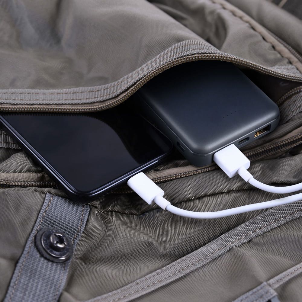 Phone chargingpowerbank charges smartphonecellphone with energy bank Depth of field on Power bank in the backpack bag - Hidalgo