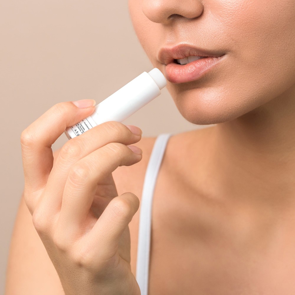lips care and protection woman applying balm on lips - Hidalgo