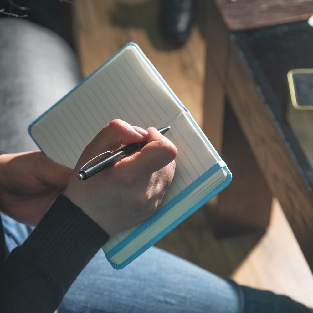 Caucasian woman writes in notepad Business - Hidalgo