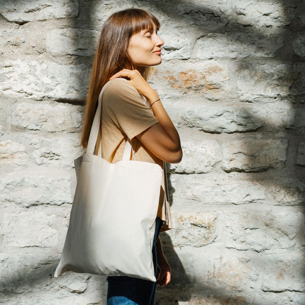 Woman holding black canvas tote bag Bag mockup for design - Katoenendraagtassen